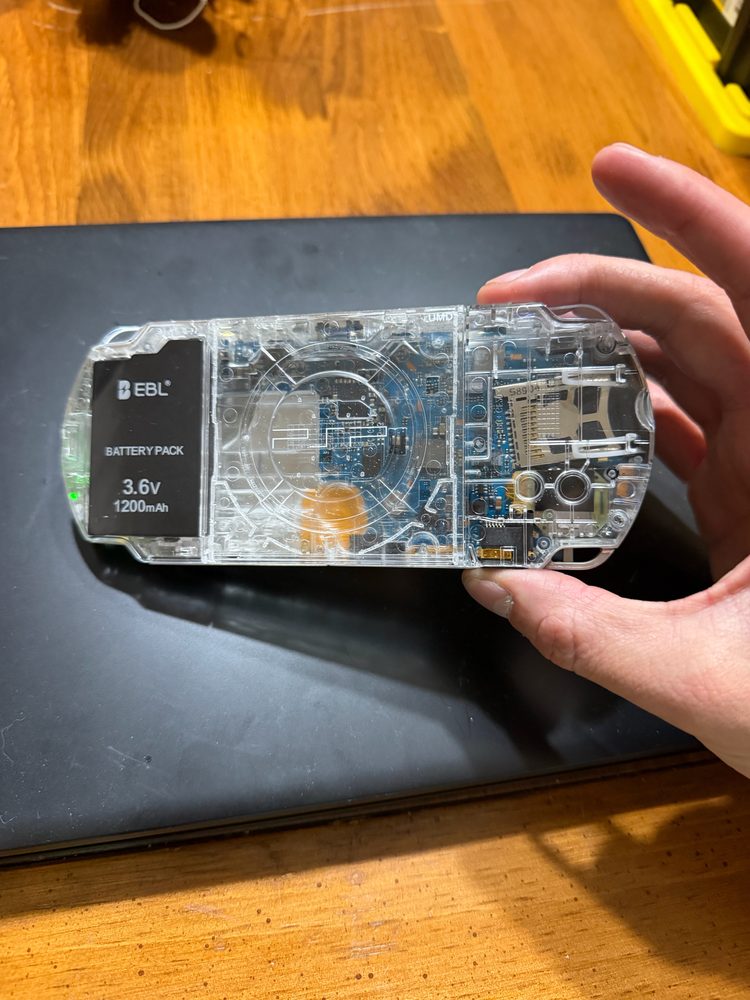 Transparent PSP-3000. UMD removed for extended battery mod.
